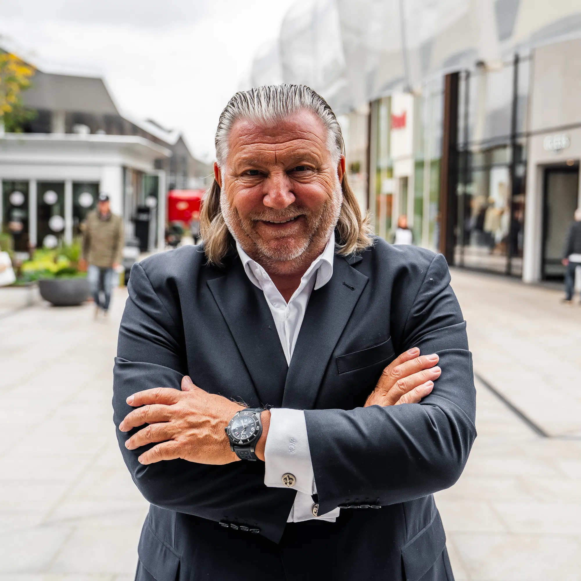 H2K Geschäftsführer steht mit verschränkten Armen vor dem Westfield Ruhr Park in Bochum und lächelt in die Kamera.